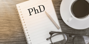 A notebook with "PhD" written on the cover, symbolizing advanced studies and academic aspirations.