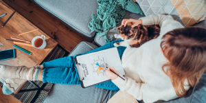 International student working while referencing a paper with the words "Work-Life Balance" written on it.