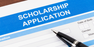 A close-up of a scholarship application form with a pen, representing the process of applying for financial aid.