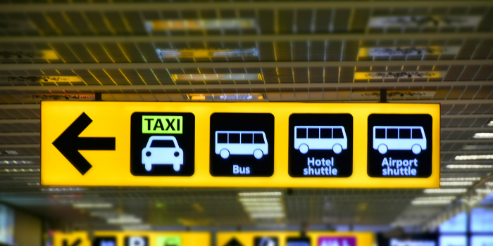 Airport transportation signs in Türkiye showing directions for taxi, bus, hotel shuttle, and airport shuttle services